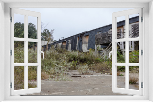 Fototapeta Naklejka Na Ścianę Okno 3D - Remains of abandoned apartment complex with overgrown grass