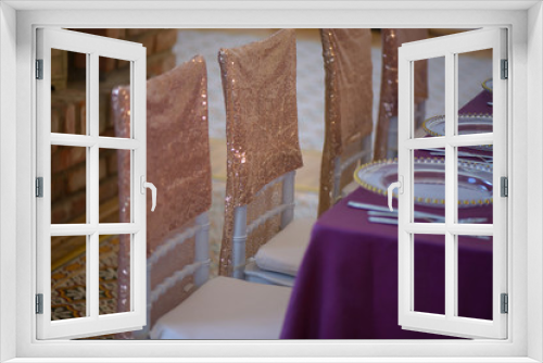 Fototapeta Naklejka Na Ścianę Okno 3D - Sitting arrangement at a fine dining restaurant or event featuring transparent plates with golden details, glassware and silverware in the order of use with purple table cloth and sequins chair covers