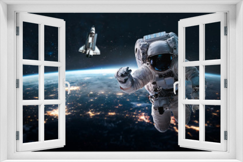Fototapeta Naklejka Na Ścianę Okno 3D - Astronaut in outer space near Earth planet. Space shuttle and stars on background. Elements of this image furnished by NASA.