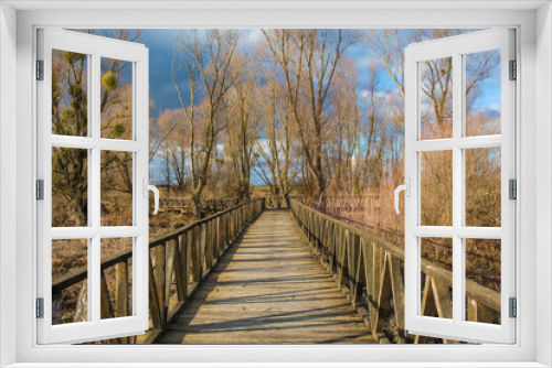 Fototapeta Naklejka Na Ścianę Okno 3D - A wooden walkway in the Kopacki Rit Nature Reserve in winter in north east Croatia. Located by the Serbian border, close to the confluence of the Drava and Danube rivers, it is one of the largest and 