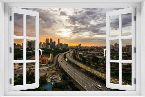 Fototapeta Naklejka Na Ścianę Okno 3D - Kuala Lumpur city skyline during dramatic sunset with elevated highway leading into the city.