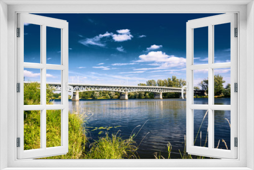 Fototapeta Naklejka Na Ścianę Okno 3D - Steel bridge across the river Elbe in the town of Litomerice in the Czech Republic. Bridge in summer sunny day. Metal construction of arched bridge with pillars over the river. Architectural monument 