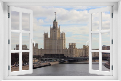 Fototapeta Naklejka Na Ścianę Okno 3D - High-rise building on Kotelnicheskaya embankment, river and bridge in Moscow - view from the floating bridge in early spring in Russia