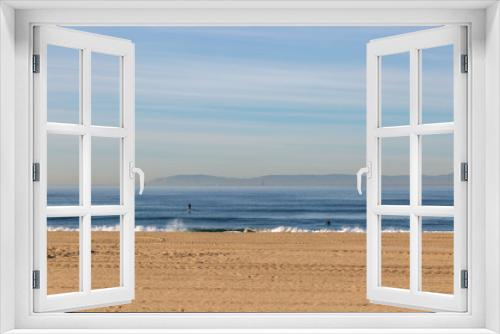 Fototapeta Naklejka Na Ścianę Okno 3D - Looking out to sea from Huntington Beach on the Californian coast, with paddle boarders on the water