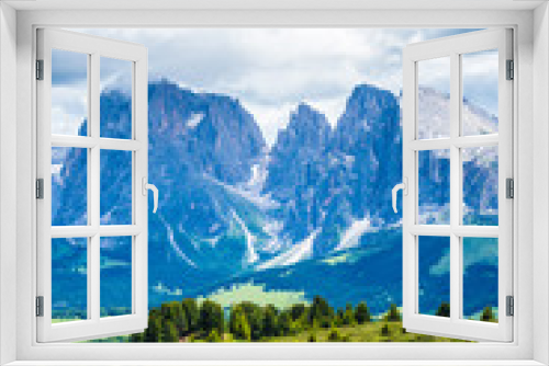 Fototapeta Naklejka Na Ścianę Okno 3D - Alpe di Siusi, Seiser Alm with Sassolungo Langkofel Dolomite, a field with a mountain in the background