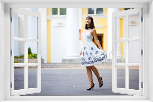 Young beautiful girl stands in front of house