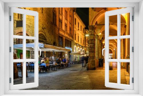 Fototapeta Naklejka Na Ścianę Okno 3D - Old narrow street with arcade in Bologna, Emilia Romagna, Italy. Night cityscape of Bologna.