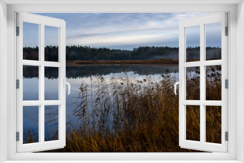 Fototapeta Naklejka Na Ścianę Okno 3D - calm lake in bright sun light with reflections of clouds and trees and blue sky