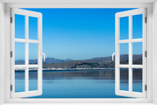 Fototapeta Naklejka Na Ścianę Okno 3D - empty vast beach covered with water, seascape with coast line and mountains on the horizon