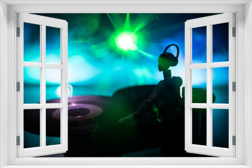 Fototapeta Naklejka Na Ścianę Okno 3D - Dj club concept. Woman DJ mixing, and Scratching in a Night Club. Girl silhouette on dj's deck, strobe lights and fog on background. Creative artwork decoration with toy.