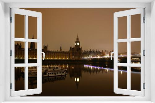 Snow covered Westminster Palace at dawn over dark grey sky