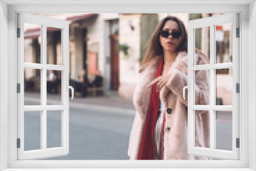 young beautiful stylish woman walking in pink coat