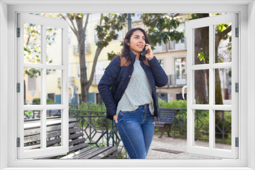 Smiling woman calling on mobile phone outdoors