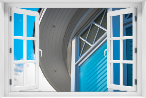 Fototapeta Naklejka Na Ścianę Okno 3D - Sun shines on window and curved awning of luxury beach house.