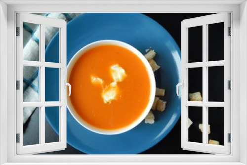 Fototapeta Naklejka Na Ścianę Okno 3D - Pumpkin cream soup on a blue plate with cream cheese and croutons on a black background