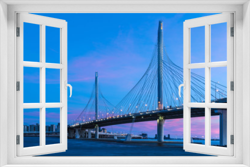Fototapeta Naklejka Na Ścianę Okno 3D - The bridge of circle highway road over Neva river near the mouth of it in the blue hour after the sunset. Night view on the buildings of Petersburg city and the Finish gulf