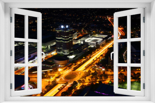Fototapeta Naklejka Na Ścianę Okno 3D - Modern European aerial night cityscape with broad circle road intersection,  commercial, office and industrial buildings in outskirts illuminated by street and car light, Munchen Bayern Germany Europe