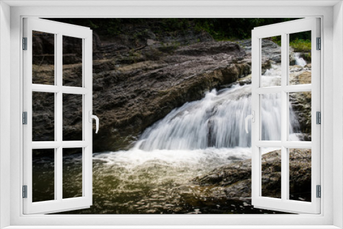 Fototapeta Naklejka Na Ścianę Okno 3D - Waterfall stream surrounded by green tropical green forest 