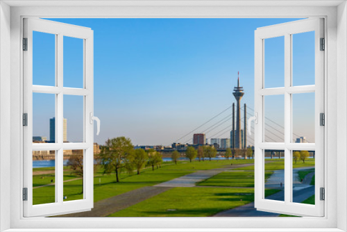 Fototapeta Naklejka Na Ścianę Okno 3D - Aerial outdoor panoramic sunny scenic landscape view of natural promenade and green field on riverside of Rhine River, and background of skyline cityscape of Düsseldorf city, Germany.