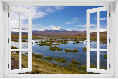 Fototapeta Naklejka Na Ścianę Okno 3D - A valley in the highlands of the Atacama Desert along the road to El Tatio Geysers, with lagoons and the snowy volcanoes of the Andes in the background, Chile