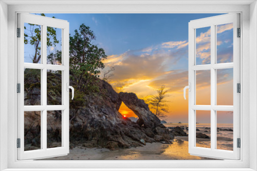 Fototapeta Naklejka Na Ścianę Okno 3D - beautiful sunset in the hole of unusual rock wave eroded into the cavity like the arch with a hole in the middle peaceful atmosphere at Hin Thalu Buffalo beach on Phayam island Ranong Thailand..