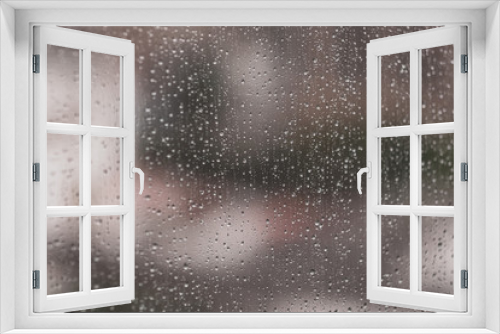 Fototapeta Naklejka Na Ścianę Okno 3D - Glass window with raindrops. Overcast day and blurred cityscape outside. Symbol of sadness, depression, sorrow. Abstract texture background with copy space for text and design. Realistic image.