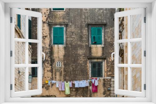 Fototapeta Naklejka Na Ścianę Okno 3D - Fassade mit einer Wäscheleine und Kleidung 