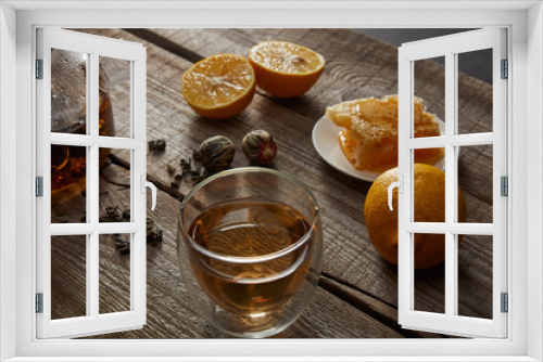 Fototapeta Naklejka Na Ścianę Okno 3D - transparent teapot with glass of chinese blooming tea, honeycomb, tea balls and lemons on wooden table