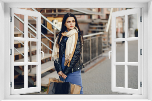 beautiful elegant girl walking around the city with shopping bags