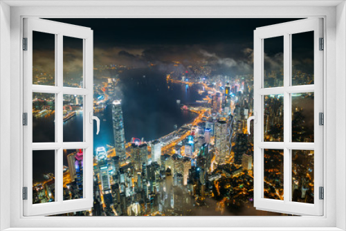 Fototapeta Naklejka Na Ścianę Okno 3D - Aerial view of Hong Kong City skyline at night over the clouds