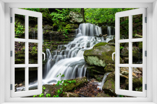 Fototapeta Naklejka Na Ścianę Okno 3D - A waterfall cascades down the lush green forest of the Arkansas Ozark Mountains between Boxley Valley and Ponca.
