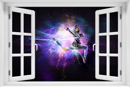 Fototapeta Naklejka Na Ścianę Okno 3D - Modern female dancer jumping in hoodie with colourful splashes background. Mixed media