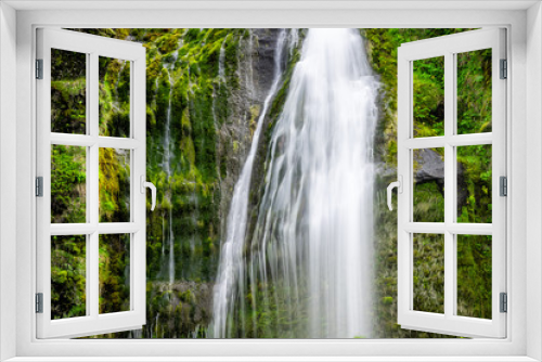 Fototapeta Naklejka Na Ścianę Okno 3D - Small waterfall by Seljalandsfoss, Iceland with closeup of long exposure smooth blurred white water falling off cliff in green mossy summer rocky landscape