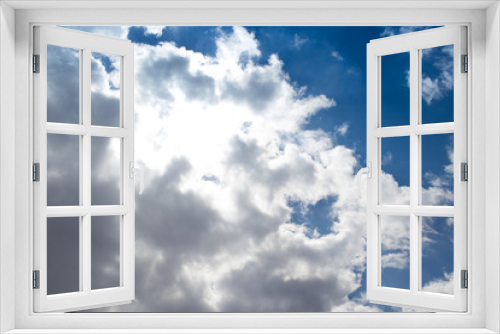 fluffy clouds with blue sky and the sun under the clouds