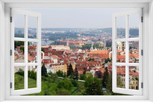 Fototapeta Naklejka Na Ścianę Okno 3D - Spring Prague City with St. Nicholas' Cathedral and green Nature with flowering Trees from the Hill Petrin, Czech Republic