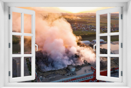 Fototapeta Naklejka Na Ścianę Okno 3D - Aerial view of burnt industrial warehouse or logistics center building after big fire with huge smoke from burned roof