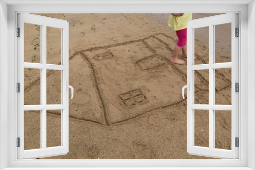 Fototapeta Naklejka Na Ścianę Okno 3D - the child draw house picture on the sand at the beach by the sea in the summer for holiday concept.