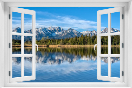 Fototapeta Naklejka Na Ścianę Okno 3D - Bergkette spiegelt sich im Alpensee - Schnee, blauer Himmel, blaues Wasser