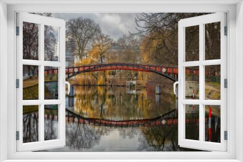 Fototapeta Naklejka Na Ścianę Okno 3D - A spring photo from the Landwehrkanal, an important canal in the German capital Berlin in the sunshine and cloudy sky with beautiful reflections in the water in front of a bridge.