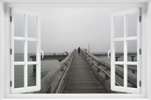 Fototapeta Naklejka Na Ścianę Okno 3D - Frau auf Seebrücke vor Horizont