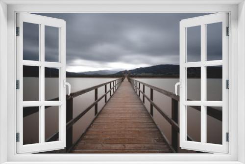 Fototapeta Naklejka Na Ścianę Okno 3D - Wooden bridge across lake on cloudy day long exposure