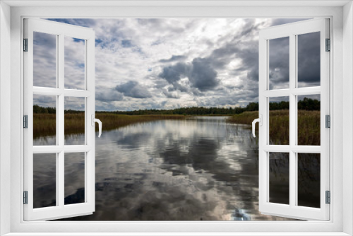 Fototapeta Naklejka Na Ścianę Okno 3D - beautiful sunset by the lake with green grass meadow and white clouds in the blue sky