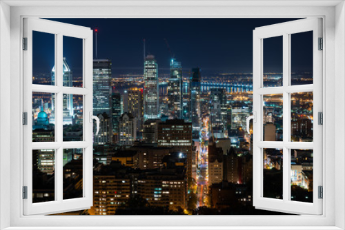 Fototapeta Naklejka Na Ścianę Okno 3D - Night view of Montreal skyline with tall skyscrapers and busy street