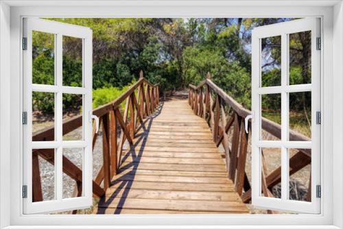 Fototapeta Naklejka Na Ścianę Okno 3D - Bridge built with logs in the interpretation center of the Albufera de Valencia and the lagoon that can be visited next to the path between nature