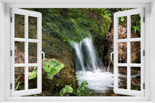 Fototapeta Naklejka Na Ścianę Okno 3D - A cascade on a small mountain creek in natural vegetation in the surroundings