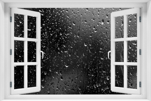Fototapeta Naklejka Na Ścianę Okno 3D - Raindrops on glass in rainy weather close up. Natural background black and white
