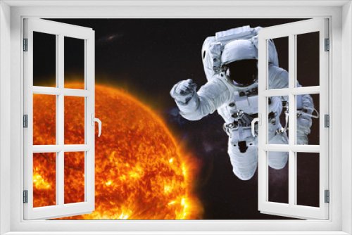 Fototapeta Naklejka Na Ścianę Okno 3D - Astronaut in outer space with Sun of solar system. Science fiction wallpaper. Elements of this image were furnished by NASA.