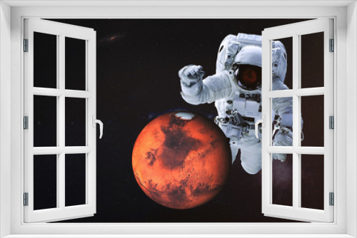 Fototapeta Naklejka Na Ścianę Okno 3D - Giant astronaut near Mars planet of Solar system. Science fiction wallpaper. Elements of the image are furnished by NASA