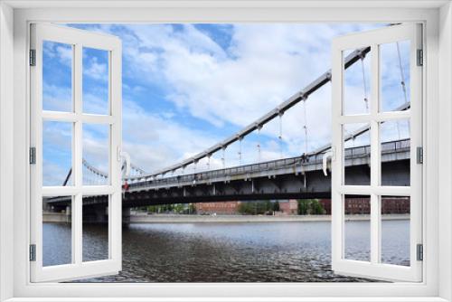 Fototapeta Naklejka Na Ścianę Okno 3D - Moscow, Russia - May 13, 2019: Crimean Bridge (Krymsky Most) across the Moskva river against the blue cloudy sky. The view from the embankment