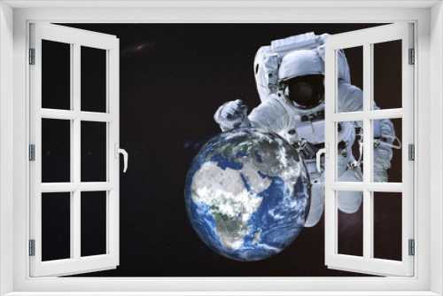 Fototapeta Naklejka Na Ścianę Okno 3D - Giant Astronaut near the Earth planet of Solar system near his hand and reflection on helmet. Science fiction. Elements of the image are furnished by NASA